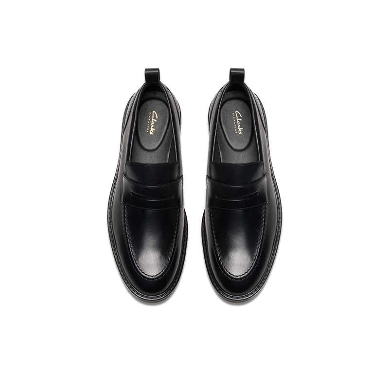 Pair of men's black leather penny loafers, top view with stitched edges