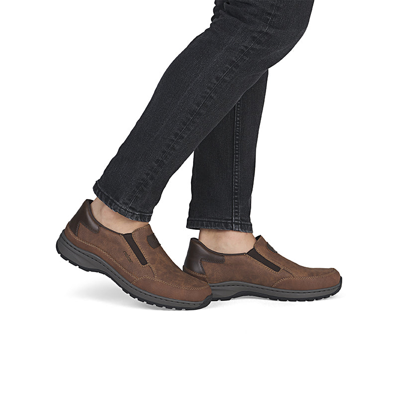 Men's slip-on sneakers worn with jeans, brown uppers and dark tread sole