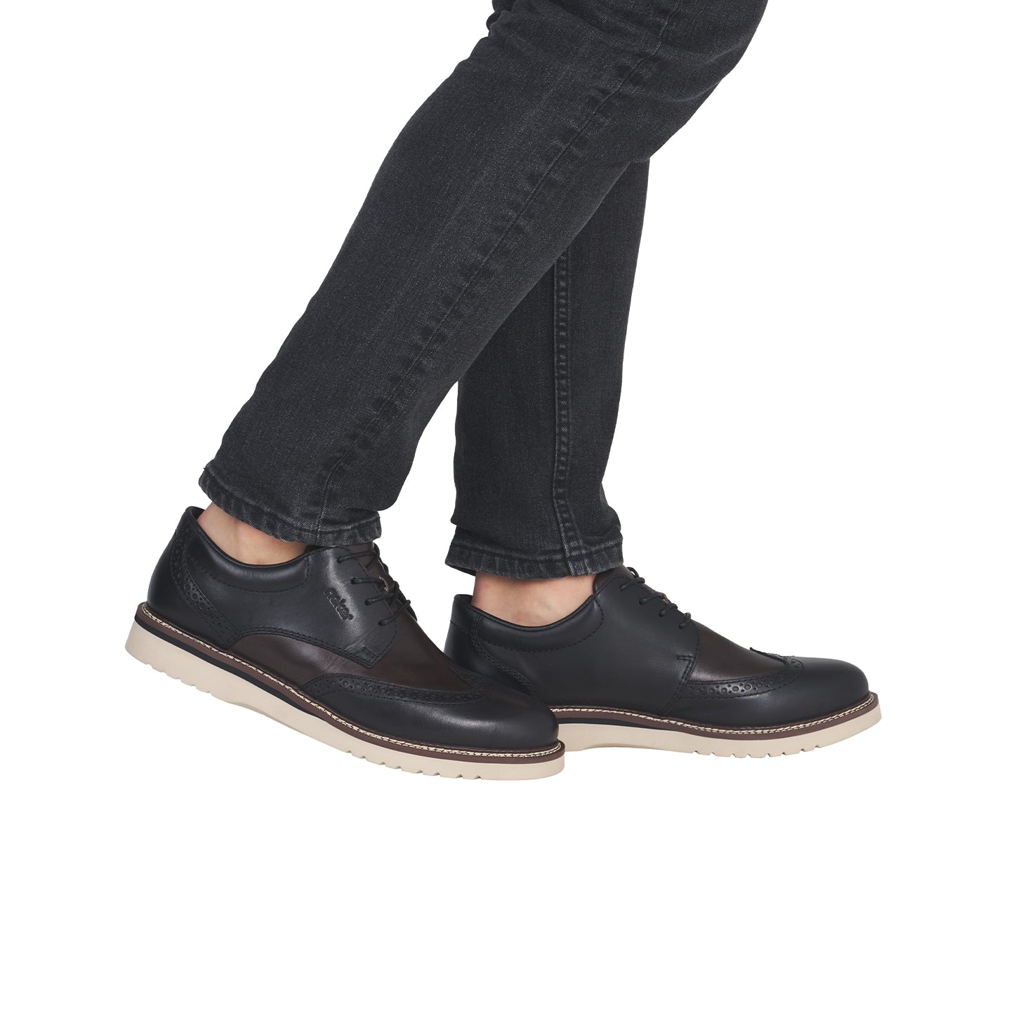 Men's brogue leather lace-up shoes, black leather with brogue perforations, on feet.
