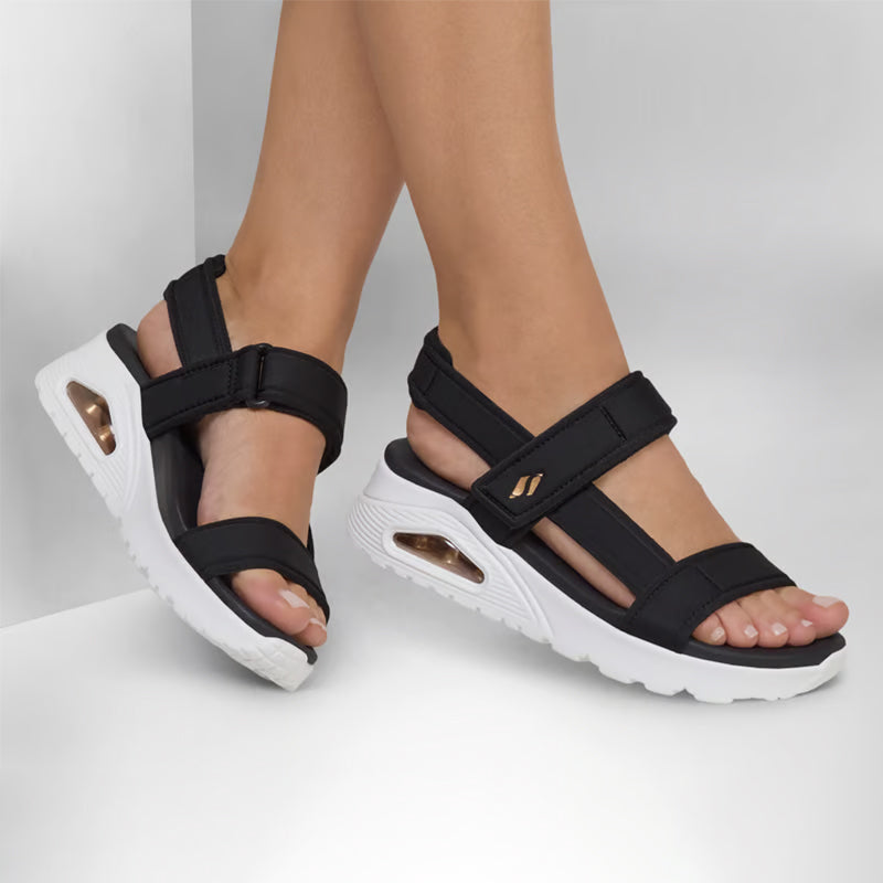 Black sport sandals with hook-and-loop straps and cushioned white sole on feet