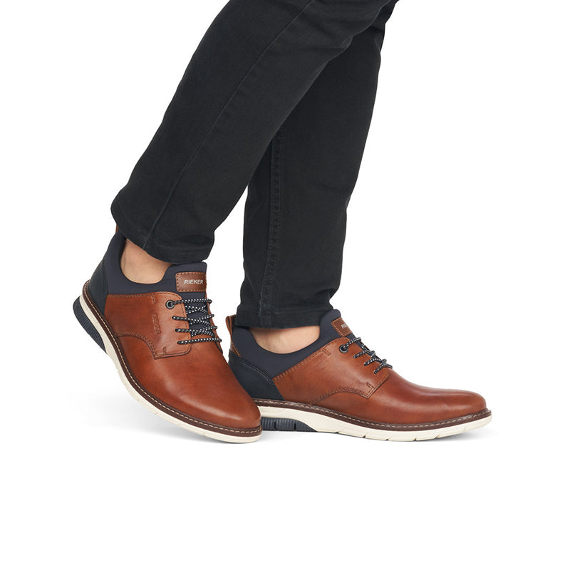 Men's brown leather lace-up shoes worn with dark ankle panels and white sole