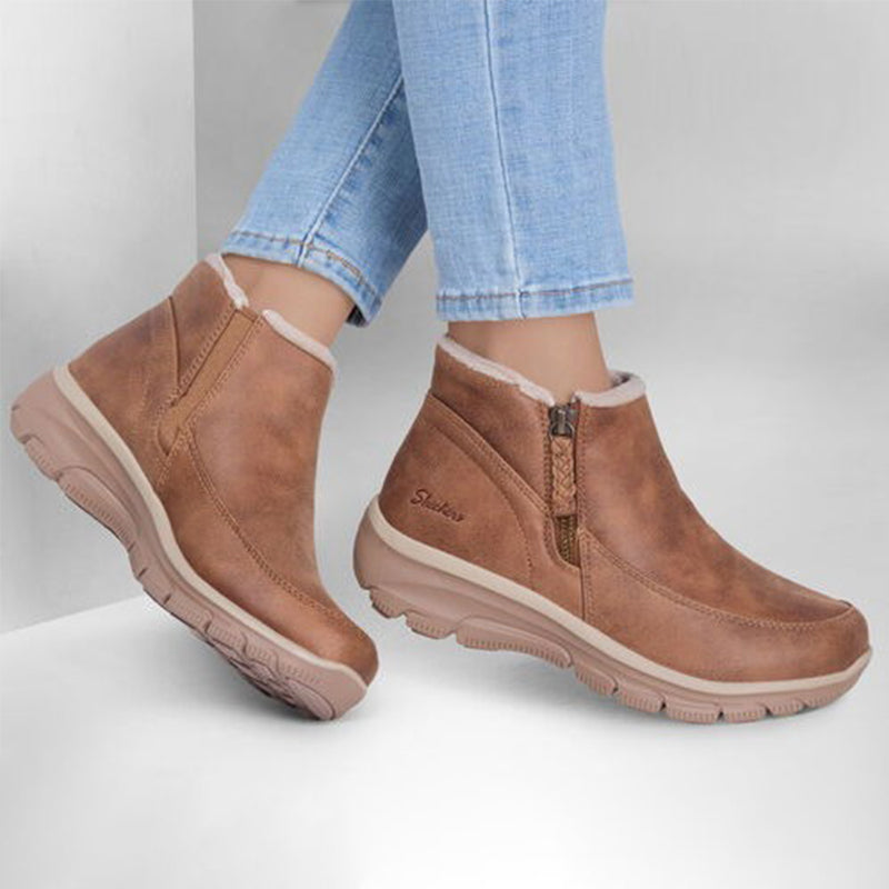 Chestnut suede side-zip boots on feet with ribbed rubber outsole