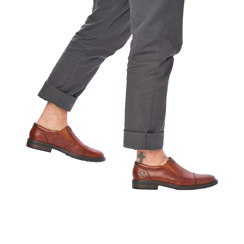 Men's chestnut leather slip-on shoes worn with dark trousers