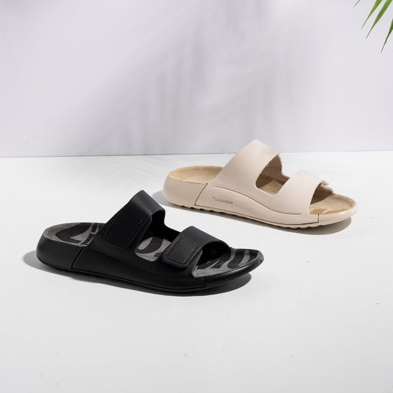 Pair of slide sandals: beige and black, each with two hook-and-loop straps
