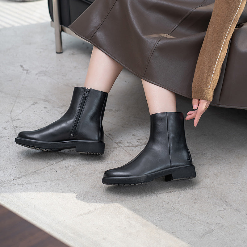 Pair of black leather ankle boots with pull-on tabs and low stacked heel
