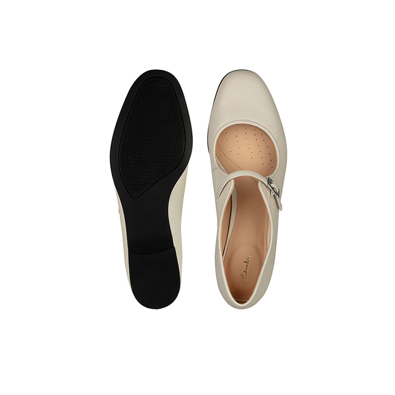White flat loafers with buckled strap; tan insole and matching dark outsole