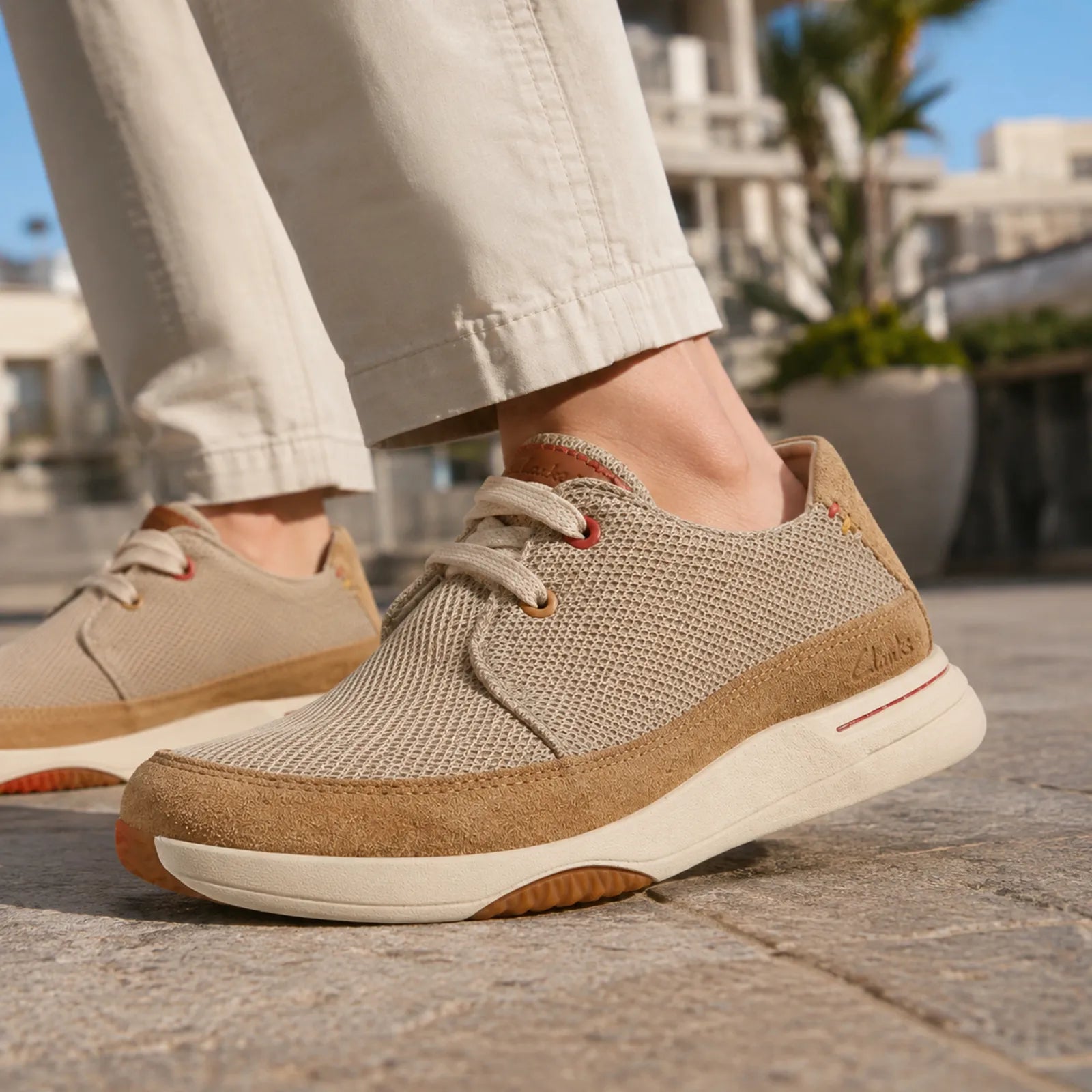 Beige lace-up sneakers with tan suede side panel and white sole for walking