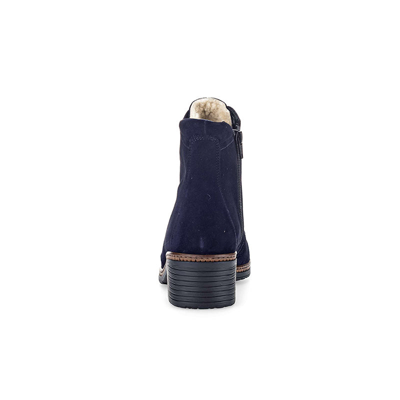 Back view of navy suede ankle boot with shearling lining and stacked heel