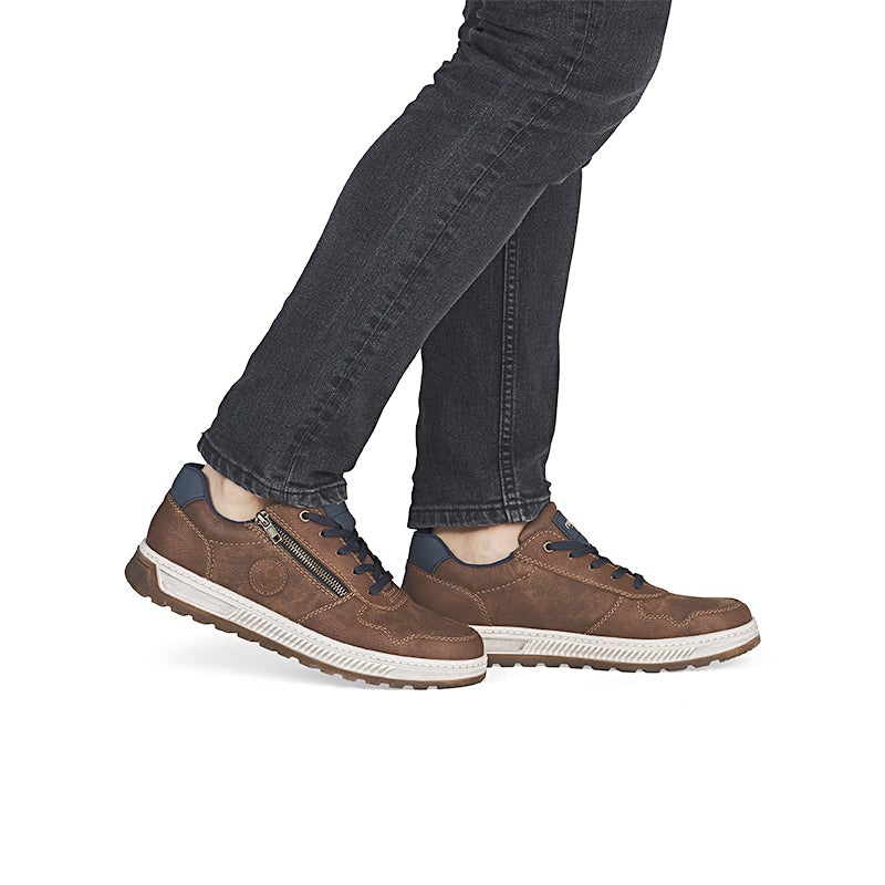 Men's brown leather sneakers on model with jeans, textured rubber sole