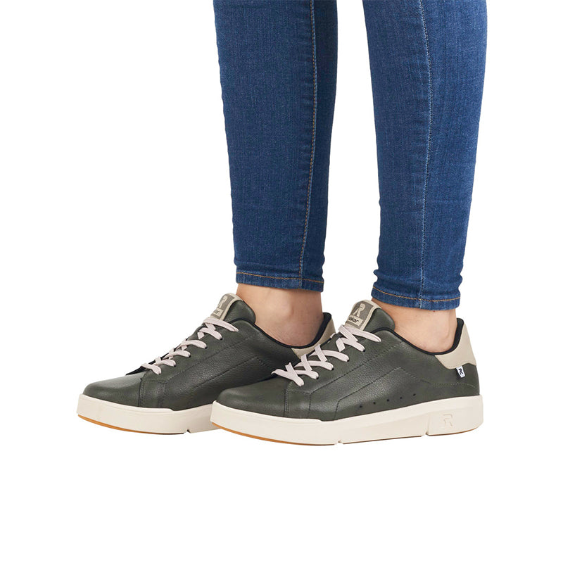 Green leather sneakers on model with blue jeans and lace-up closure