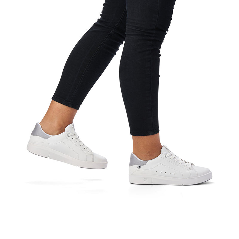 White leather sneakers on model with dark pants and lace-up design