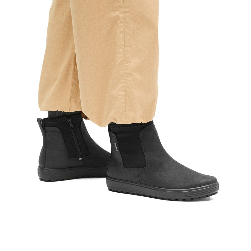 Black women's Chelsea boots with elastic gore, worn with light pants