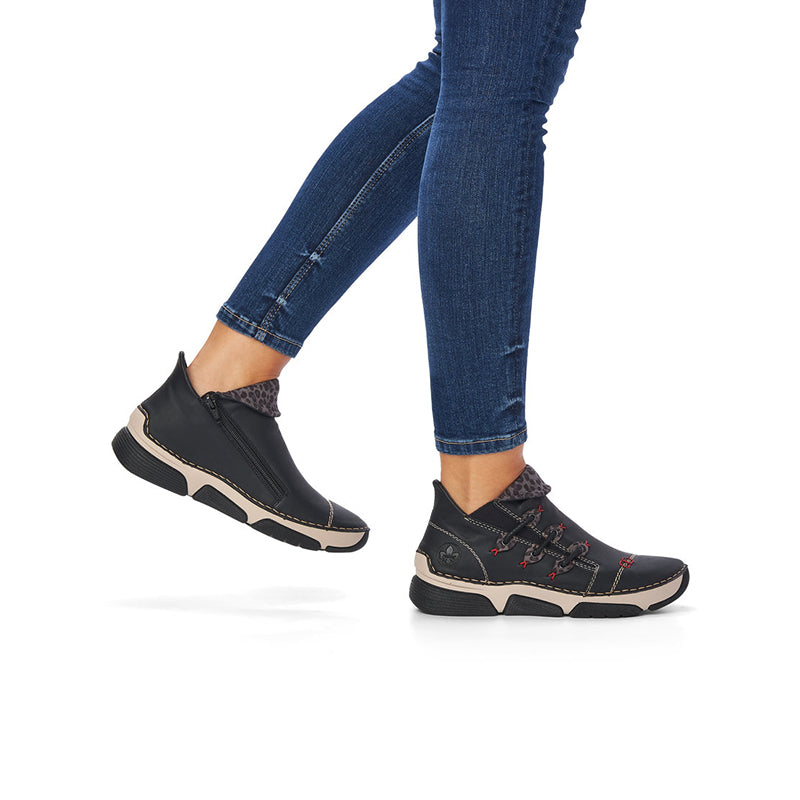 Women's black lace-up ankle boots worn with blue jeans, chunky sole