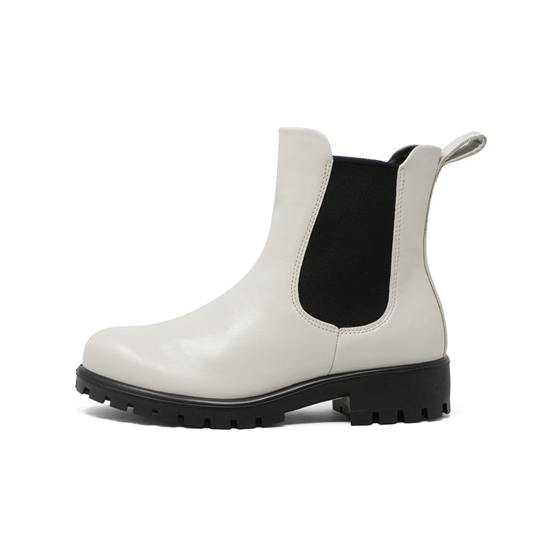 White leather Chelsea boot with elastic side panels, pull tab, and lug sole