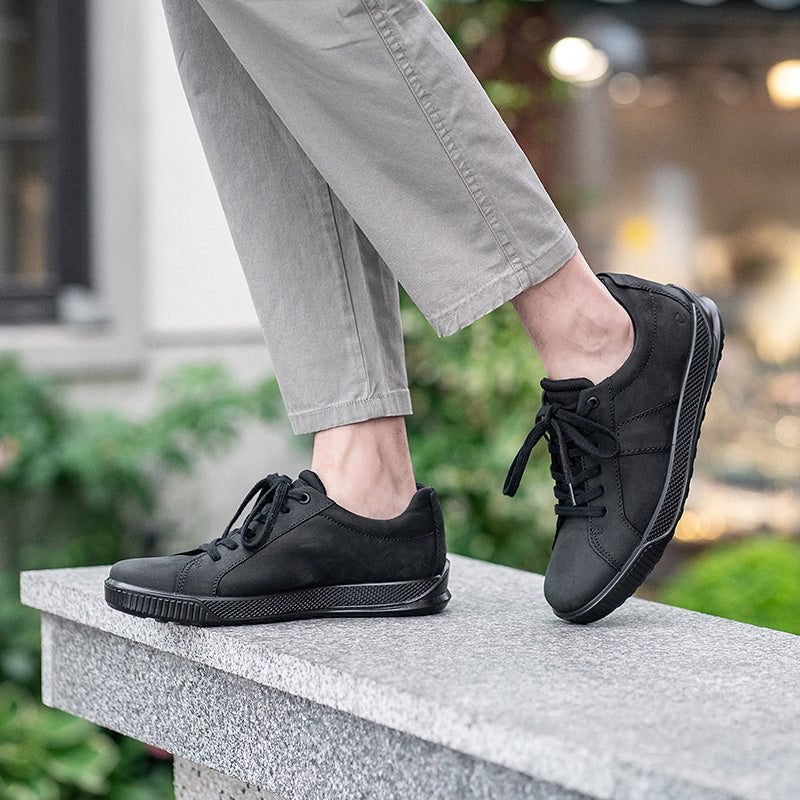 Men's black leather low-top sneakers with lace-up closure and treaded rubber sole