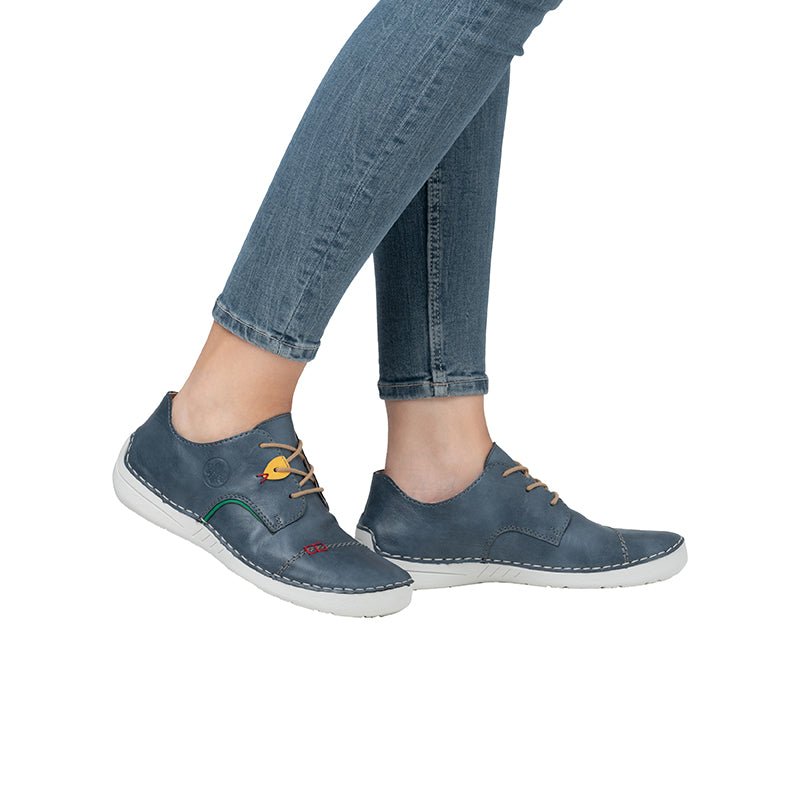 Blue lace-up sneakers on model feet with white rubber sole