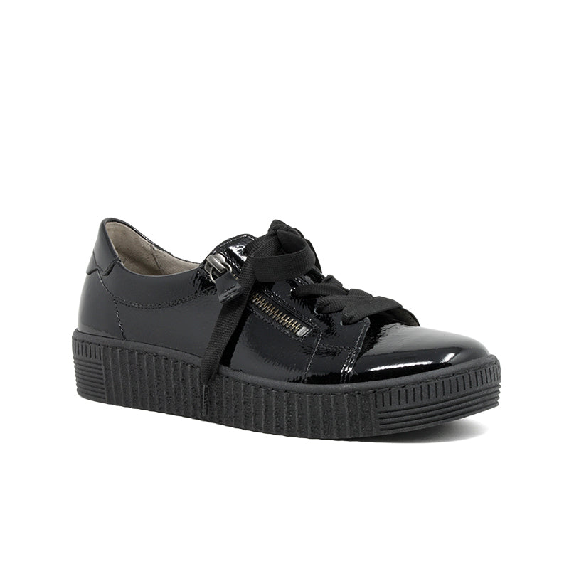 Black leather sneakers with front zipper, glossy upper, and textured rubber sole.