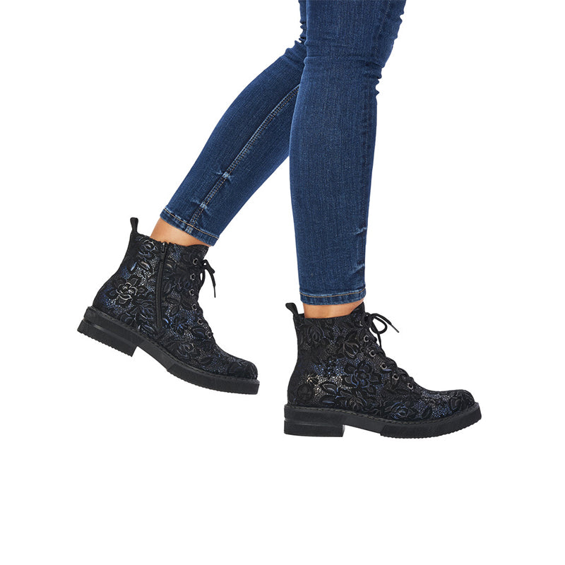 Dark patterned lace-up ankle boots worn with blue jeans, black tread sole