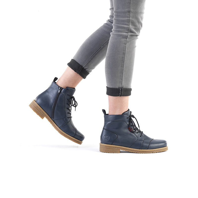 Navy-blue lace-up ankle boots with side zipper and tan tread sole