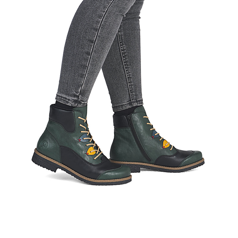 Women’s ankle boots with lace-up closure, worn with jeans, dark green and black