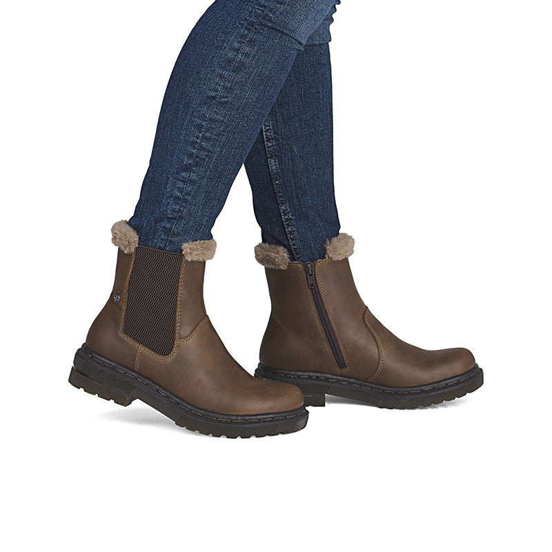 Brown ankle boots with faux-fur cuffs and side zip worn with blue jeans