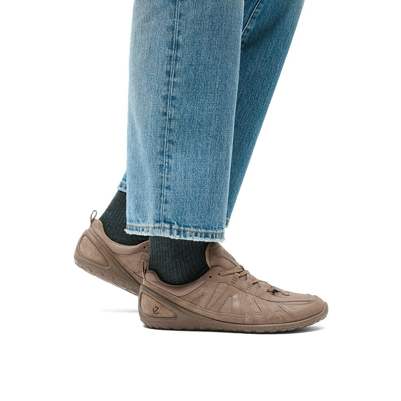 Brown athletic sneaker worn with blue jeans and knit ankle socks