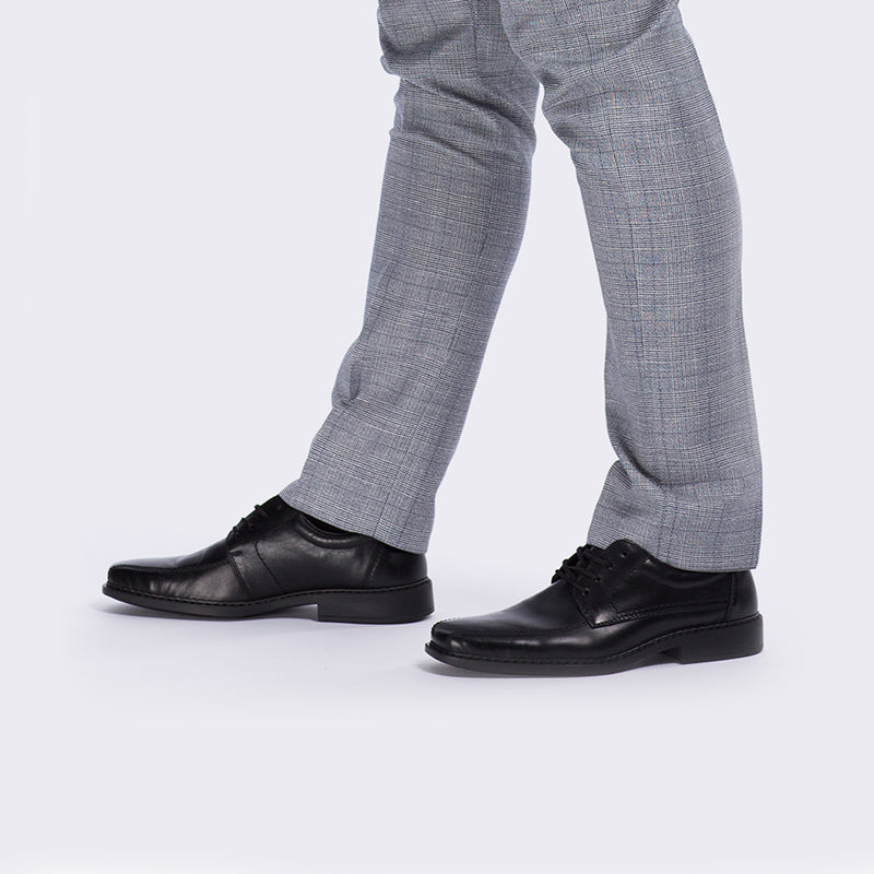 Black leather lace-up shoes worn with gray pants