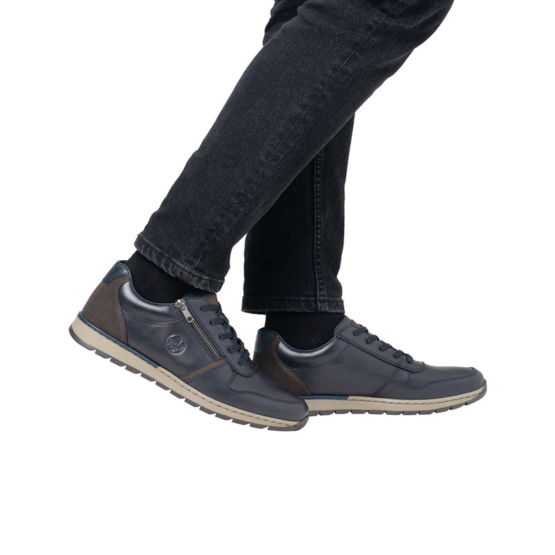 Men's lace-up zip sneaker on foot, dark blue upper with chunky rubber sole.