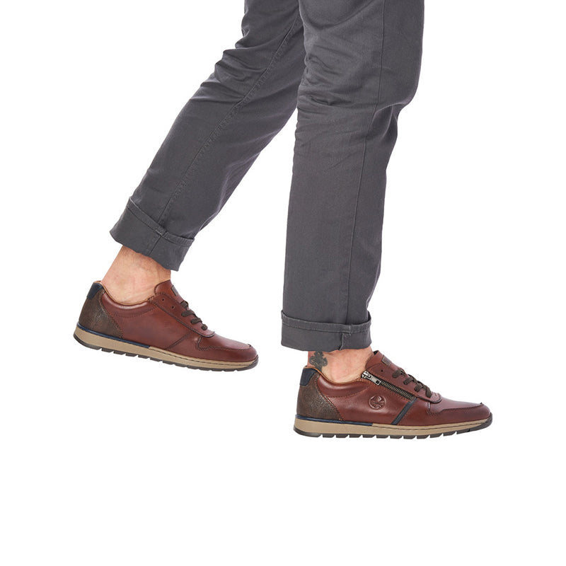 Men's lace-up zip sneaker on foot, reddish-brown upper with chunky rubber sole.