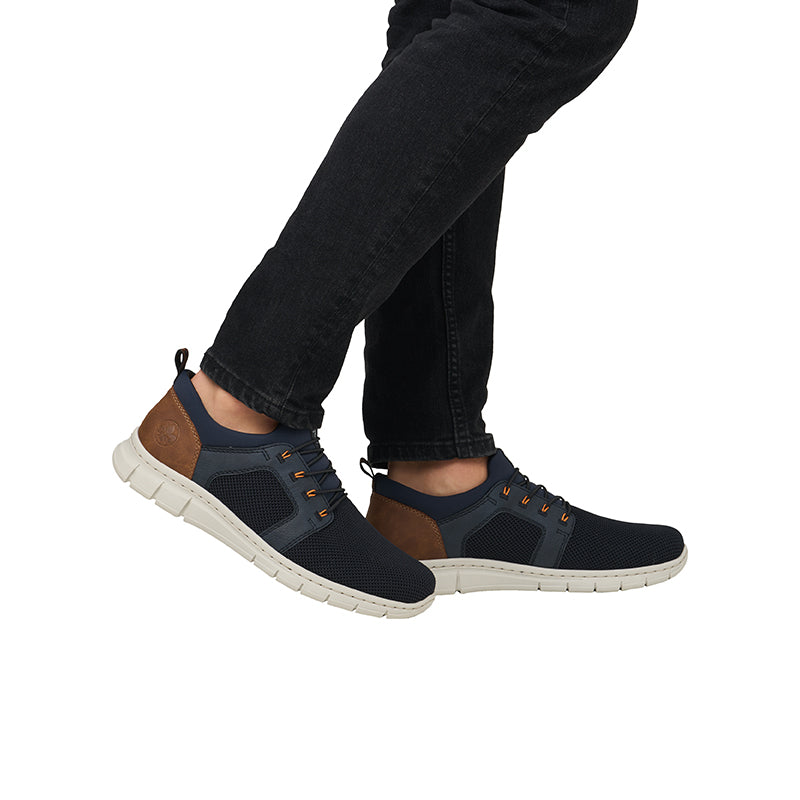 Men's blue casual sneakers on feet, brown heel panel and lace-up eyelets, low profile