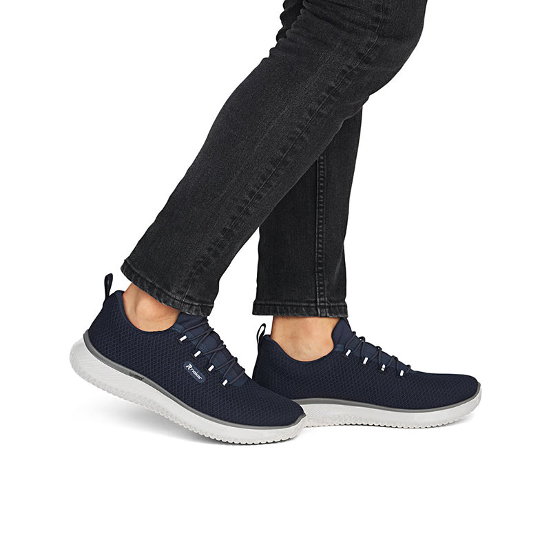 Men's slip-on sneakers, navy knit upper and lace-up front; shown with dark pants