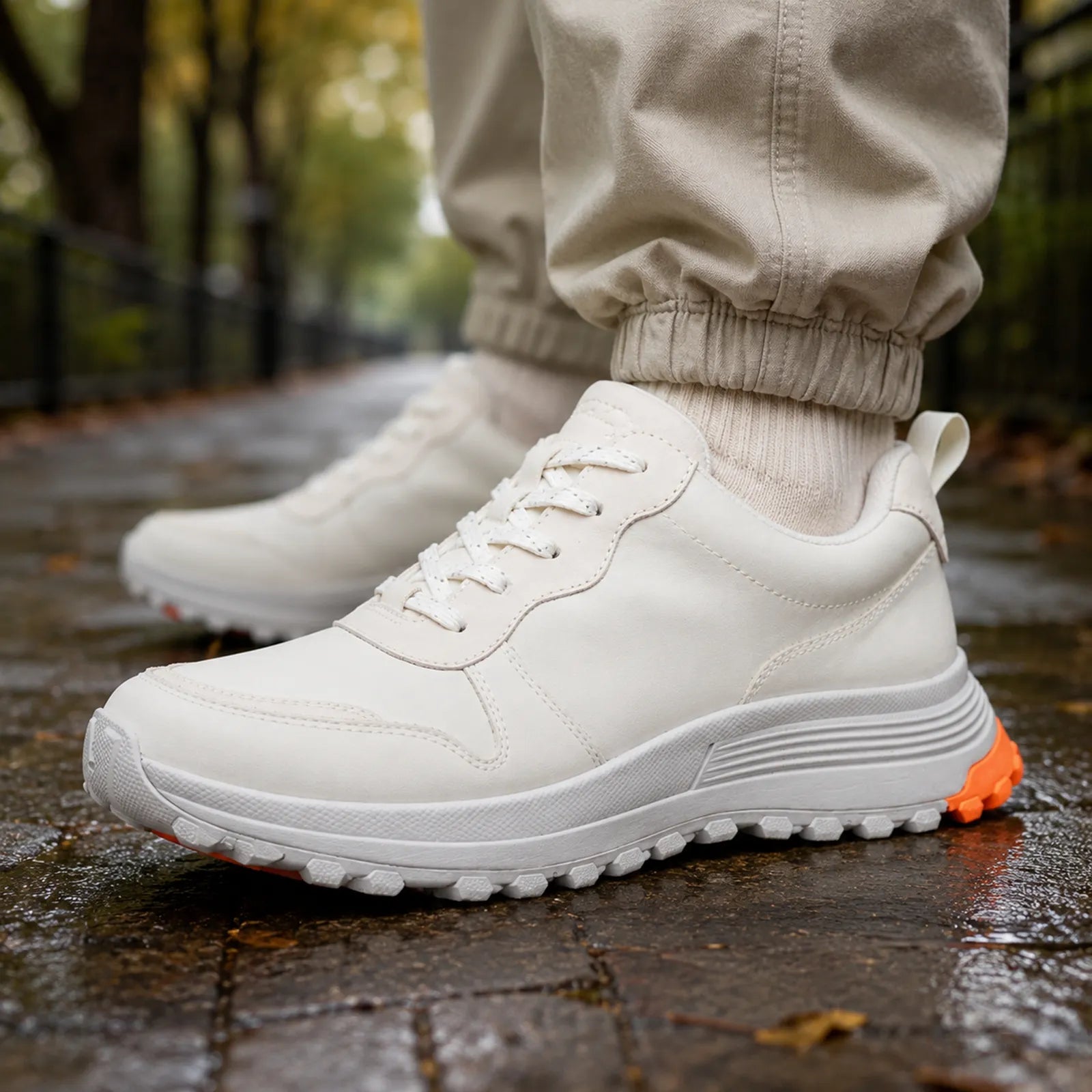 Women's white sneaker side view with laces and grippy tread, orange heel detail