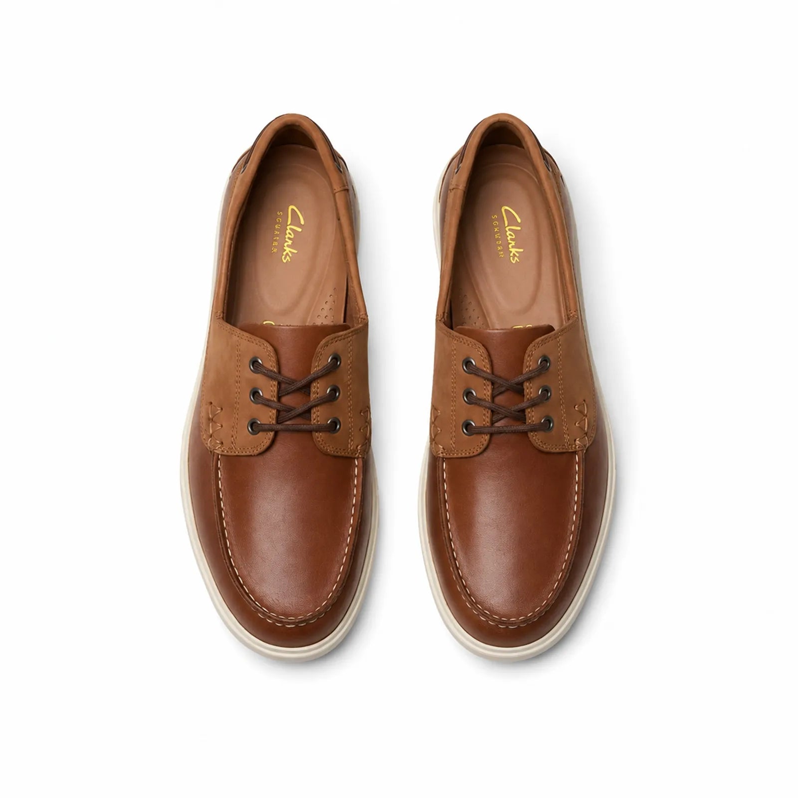 Pair of men's leather boat loafers in tan brown with lace-up and white midsoles