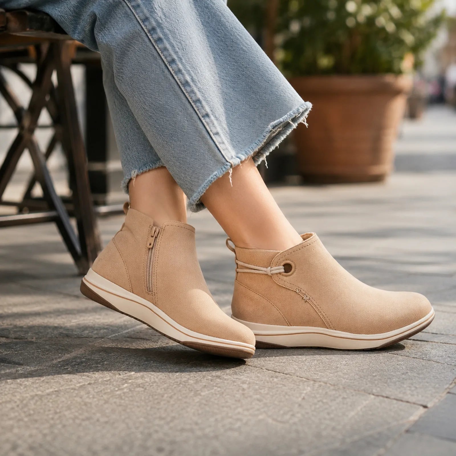 Tan ankle boots with side zip and low flexible outsole, worn with cuffed jeans