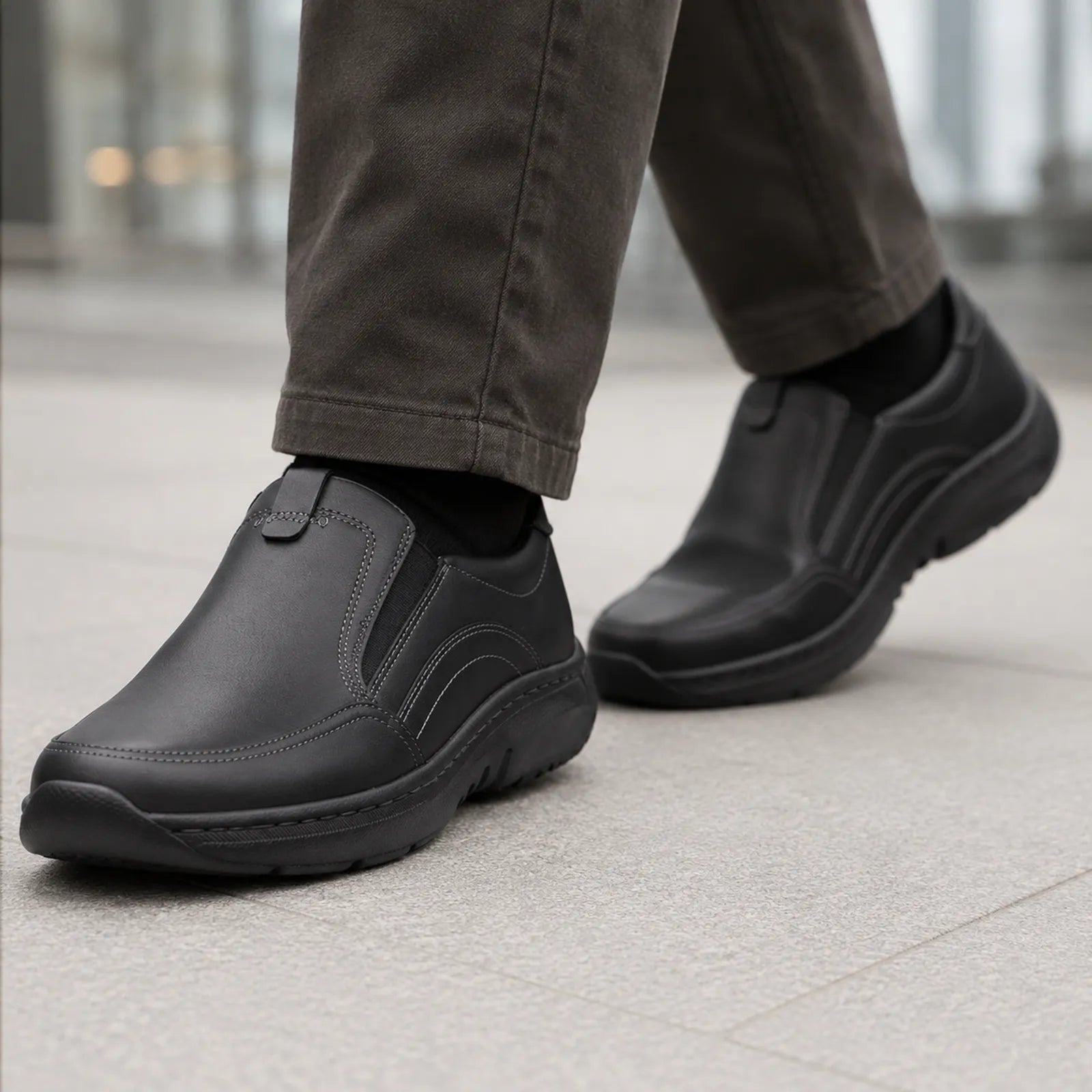 Men's black leather slip-on sneaker with cushioned collar and thick rubber sole