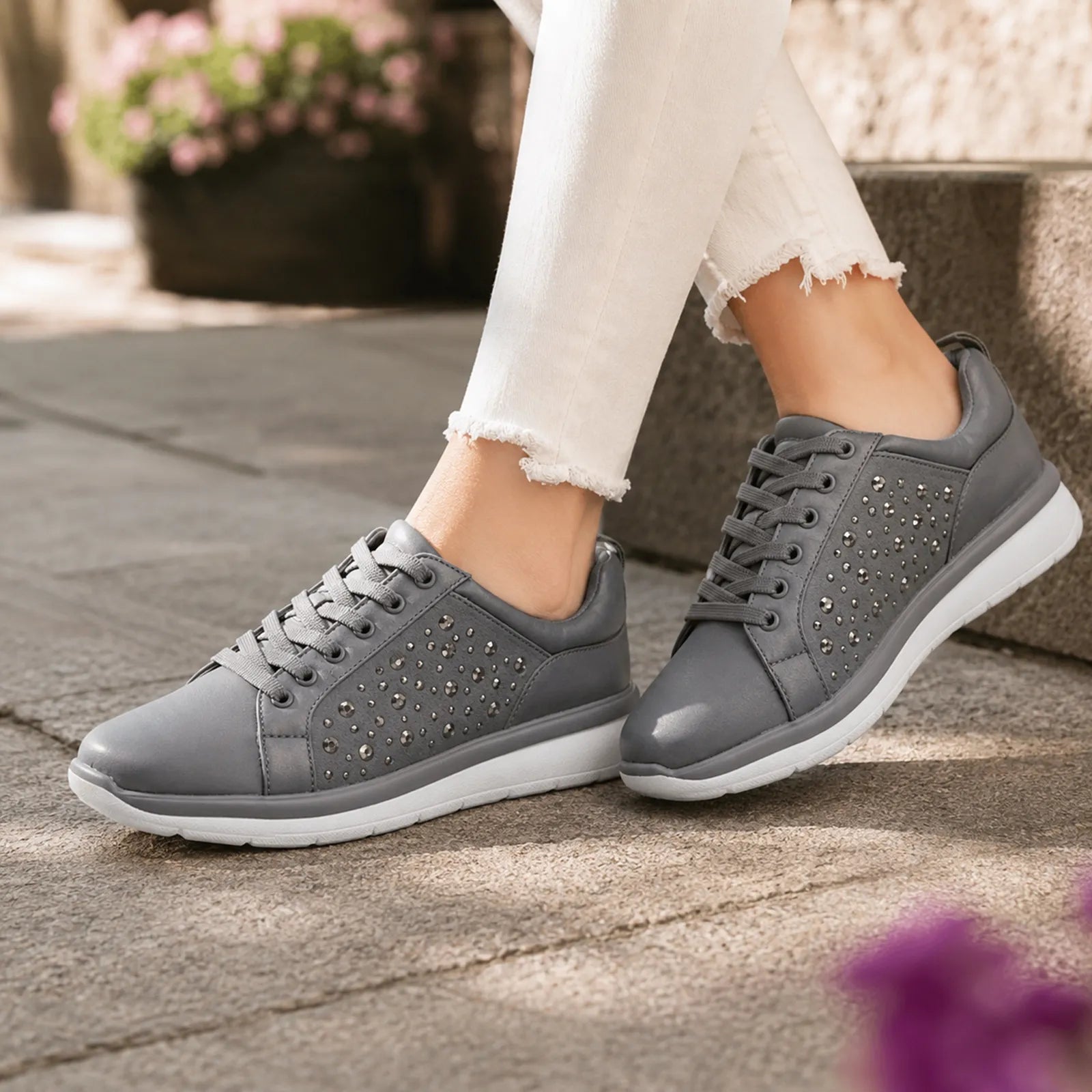 Grey metallic lace-up sneakers with rhinestone-style studded details and white sole.