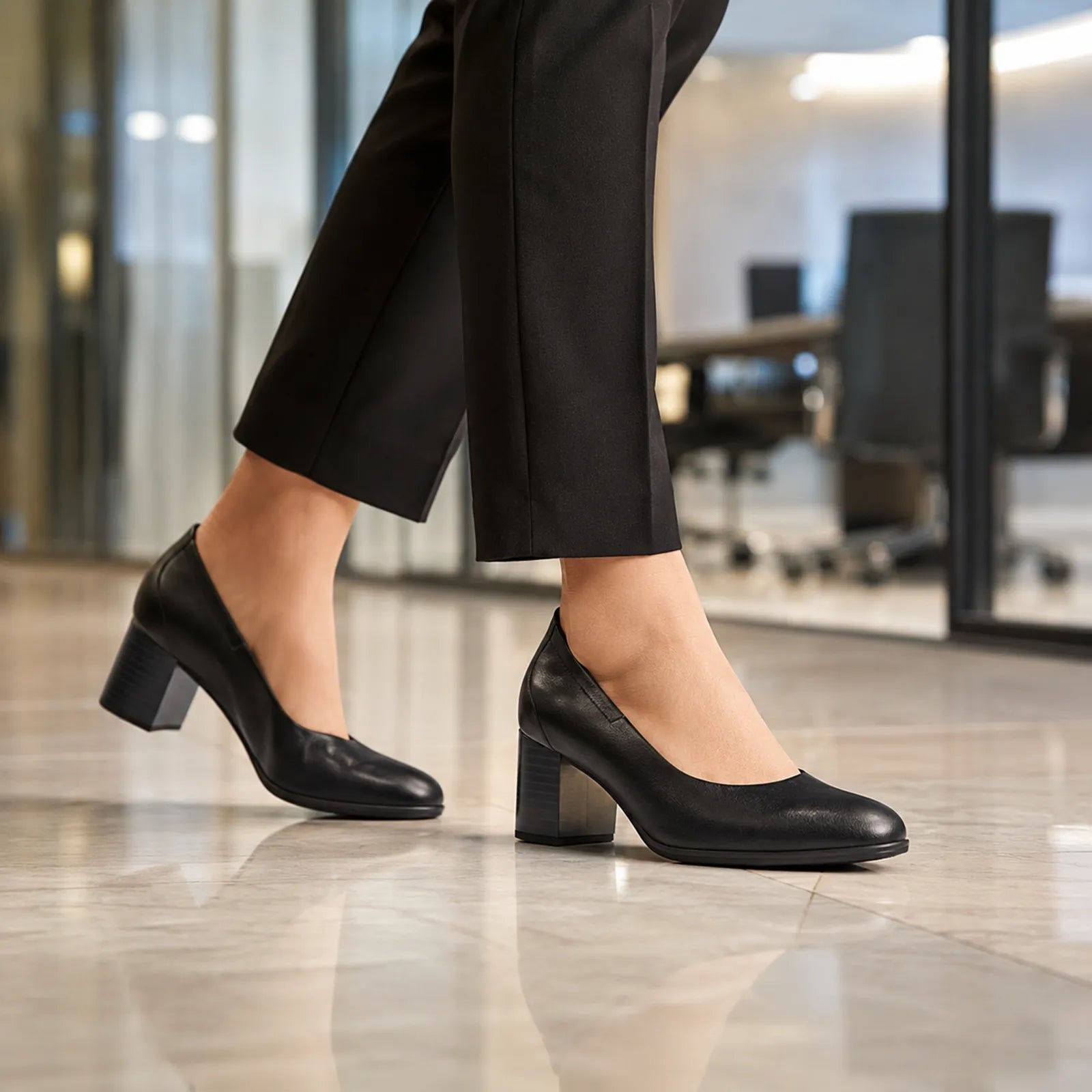 Black leather women's block-heel pumps with ankle-length dark trousers