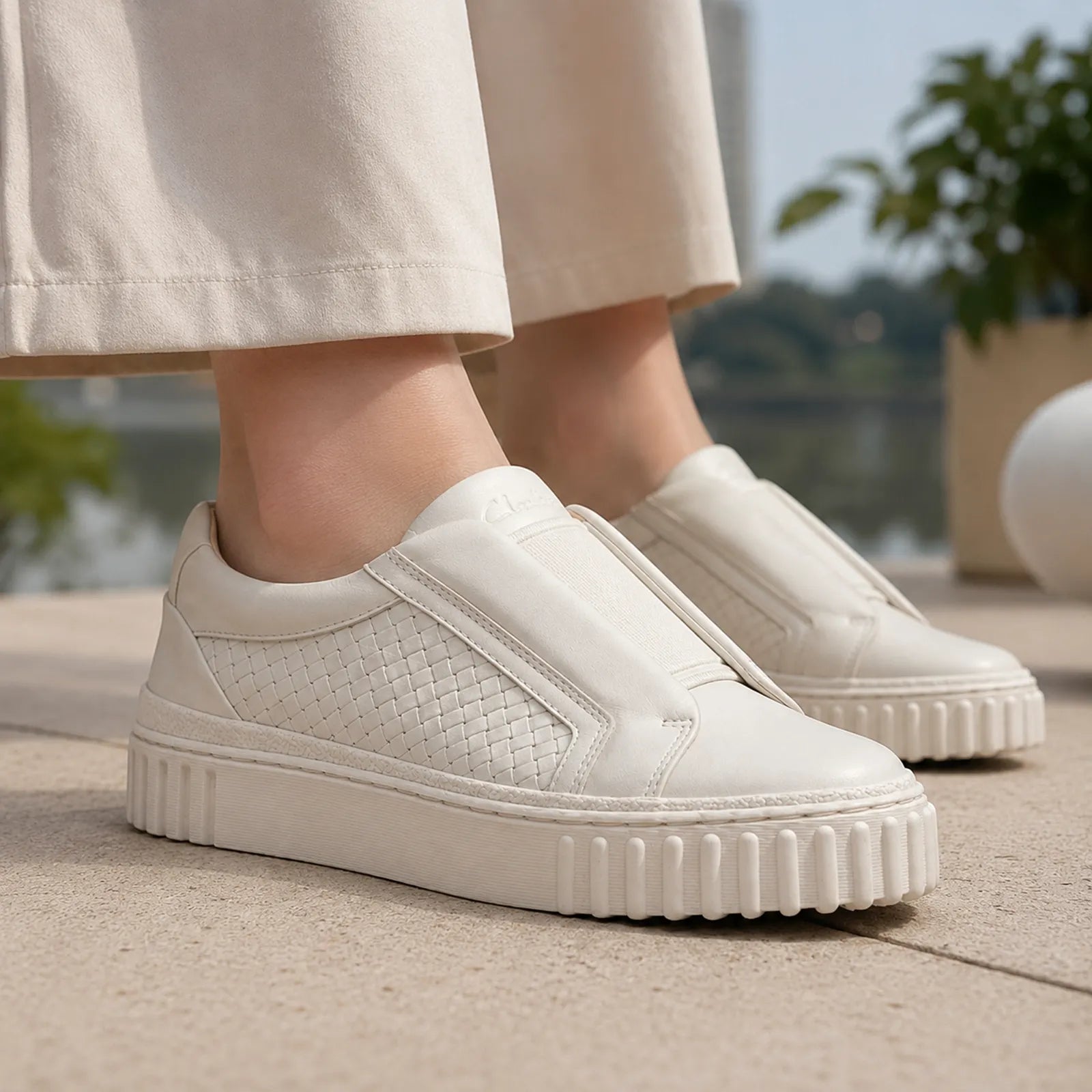 Beige leather slip-on sneakers with textured side and cushioned ribbed sole