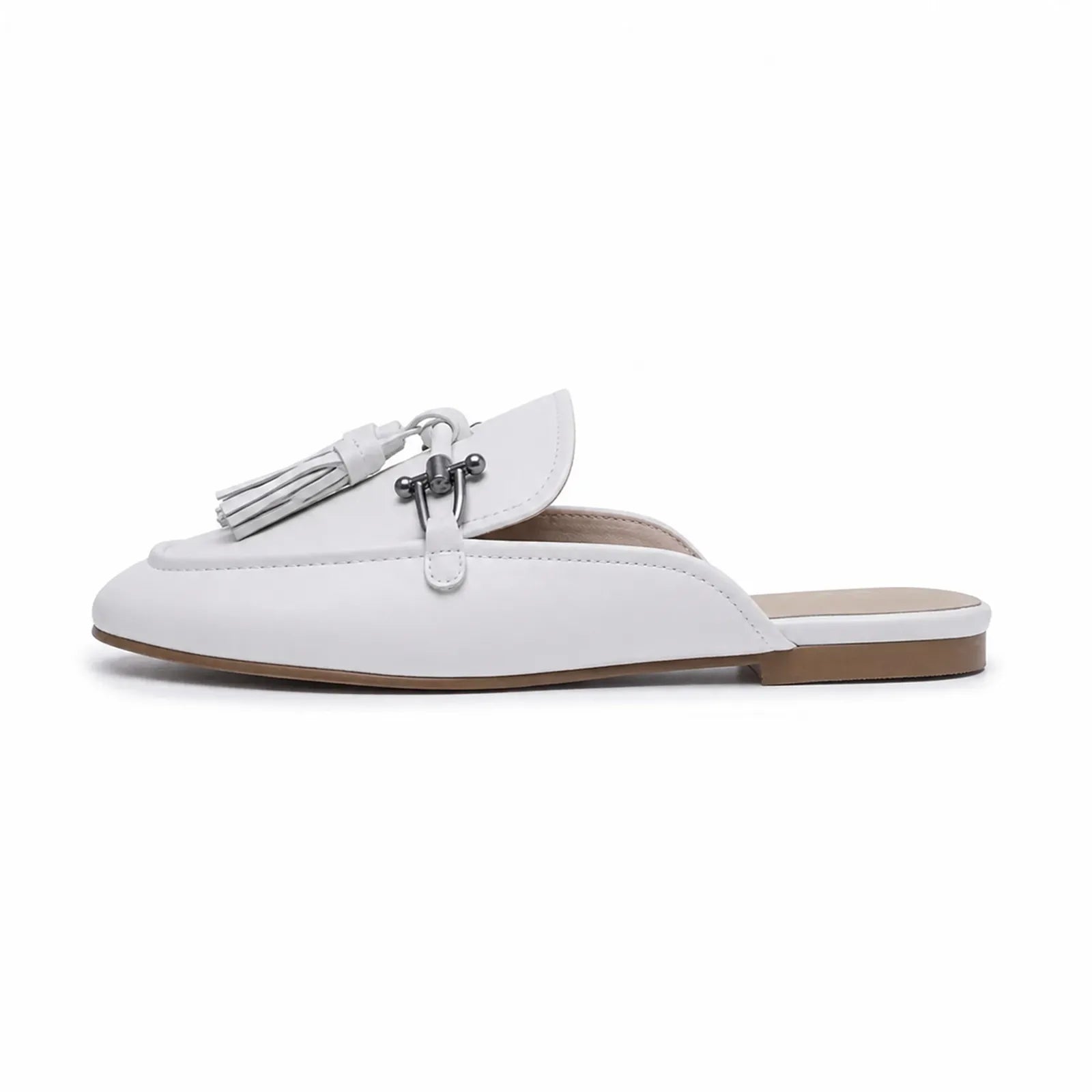 White mule flats with tassel hardware detail and open-back slip-on