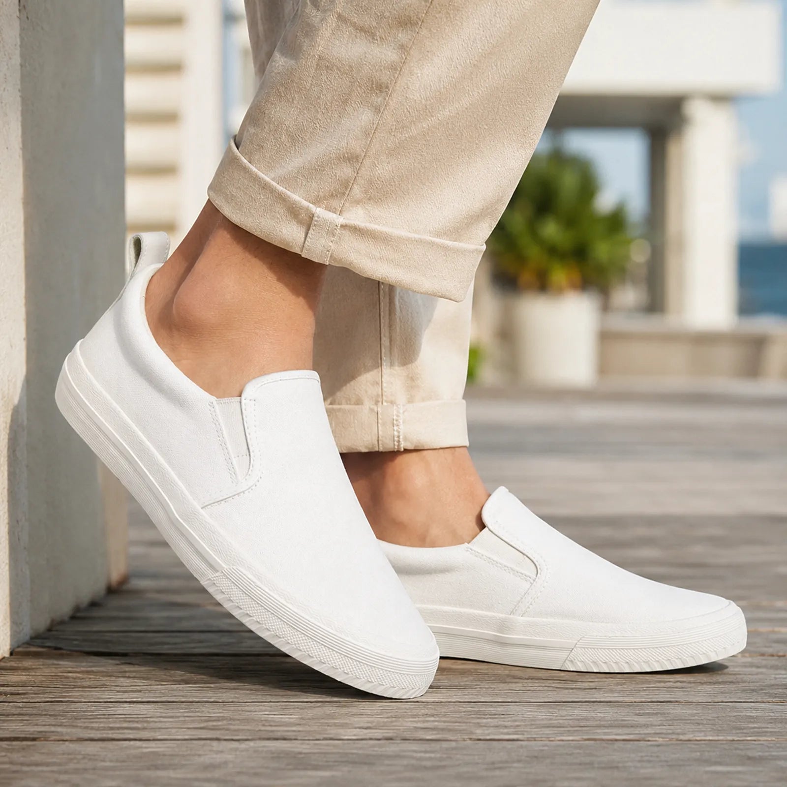 White canvas slip-on loafers with stitched side panels and rubber sole
