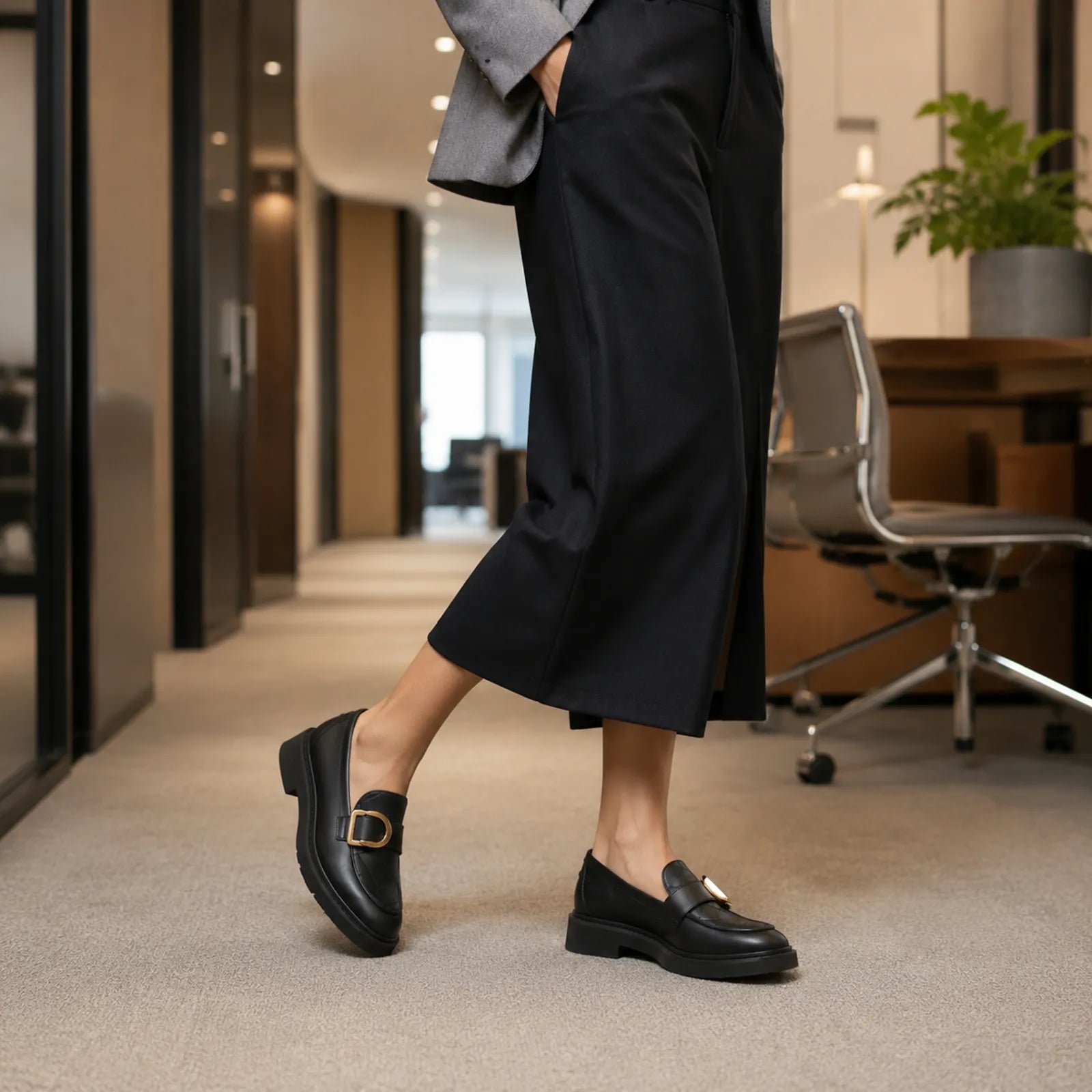 Black leather penny loafers with metal buckle on chunky outsole