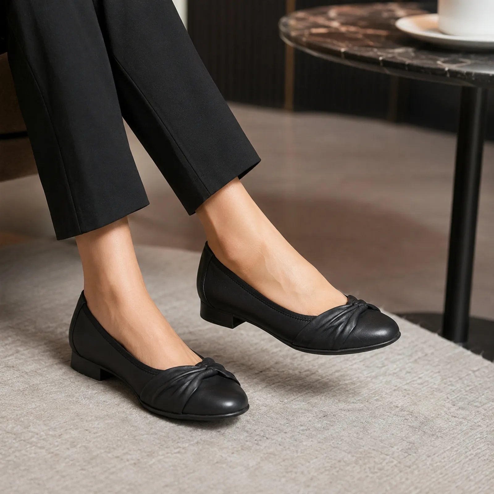 Women’s black leather flats with low block heel and twisted toe front