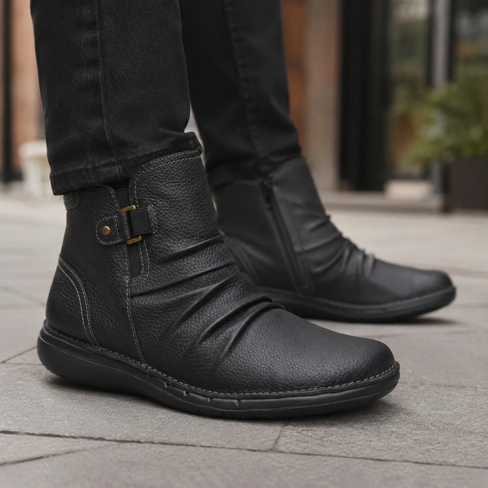 Women's black leather ankle boots with side buckle strap and rubber sole