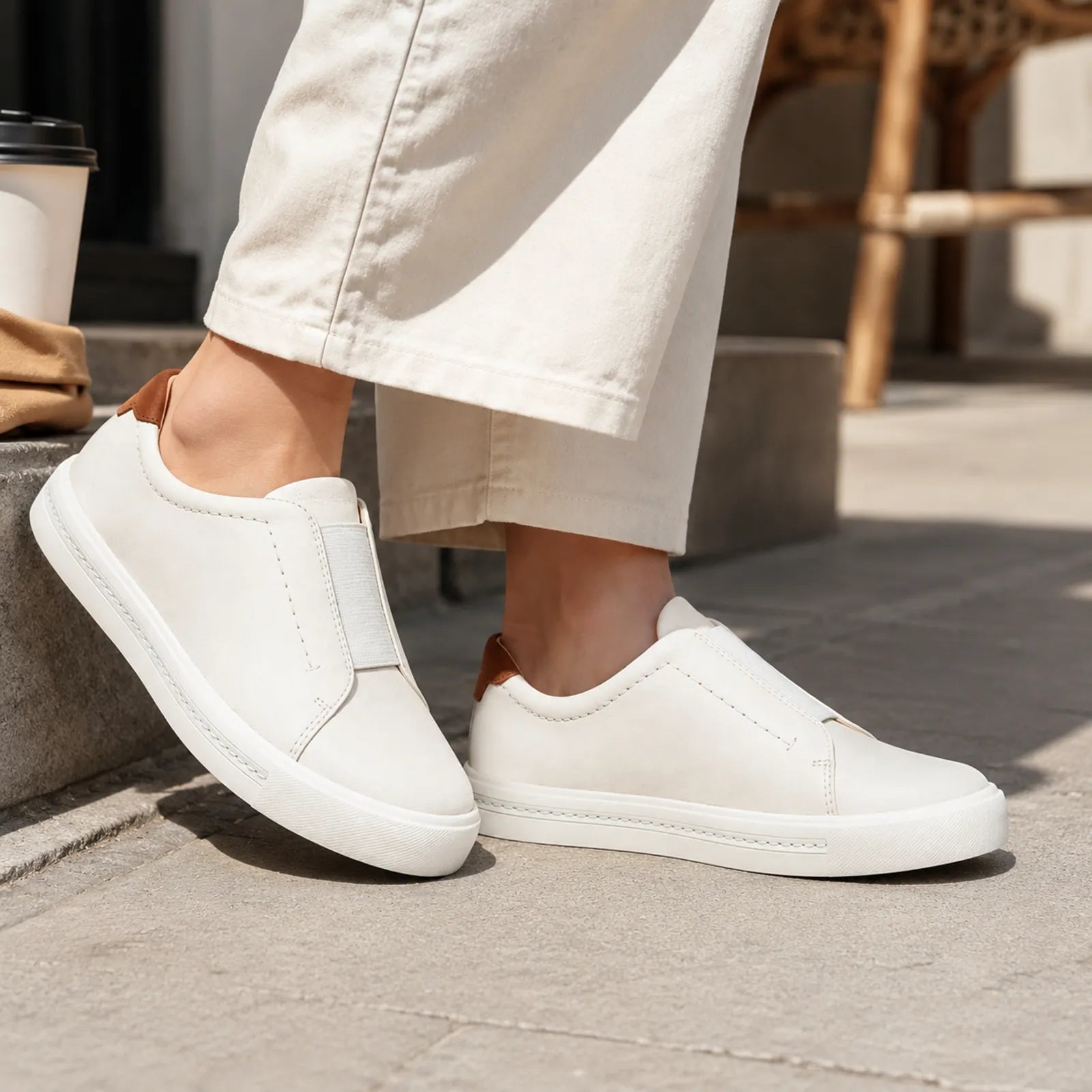 White leather slip-on sneakers with elastic side gore and low-profile sole.