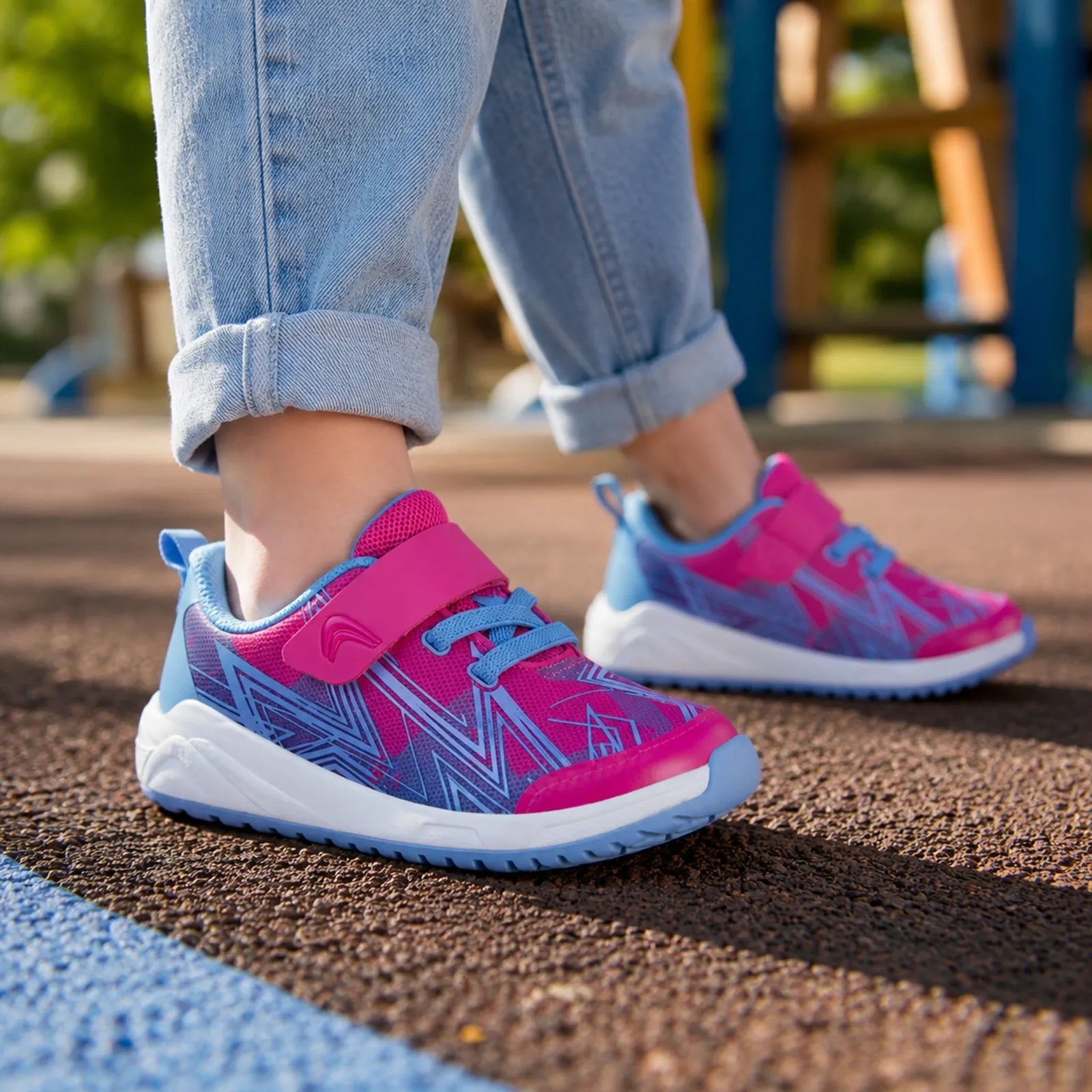 Pink and blue kids sneakers, close-up side view with hook-and-loop strap