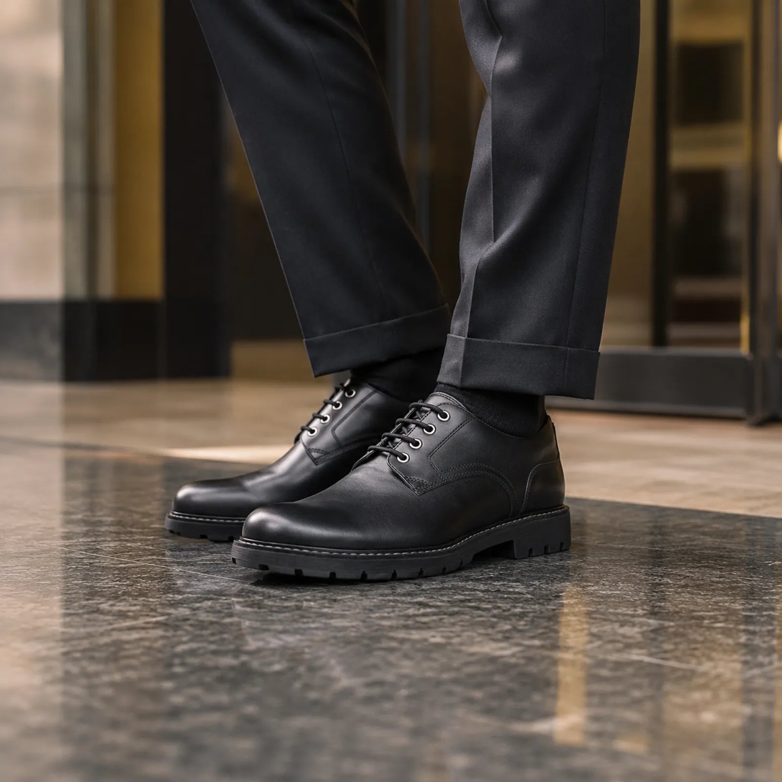 Black leather lace-up business shoes with trouser cuffs, close-up