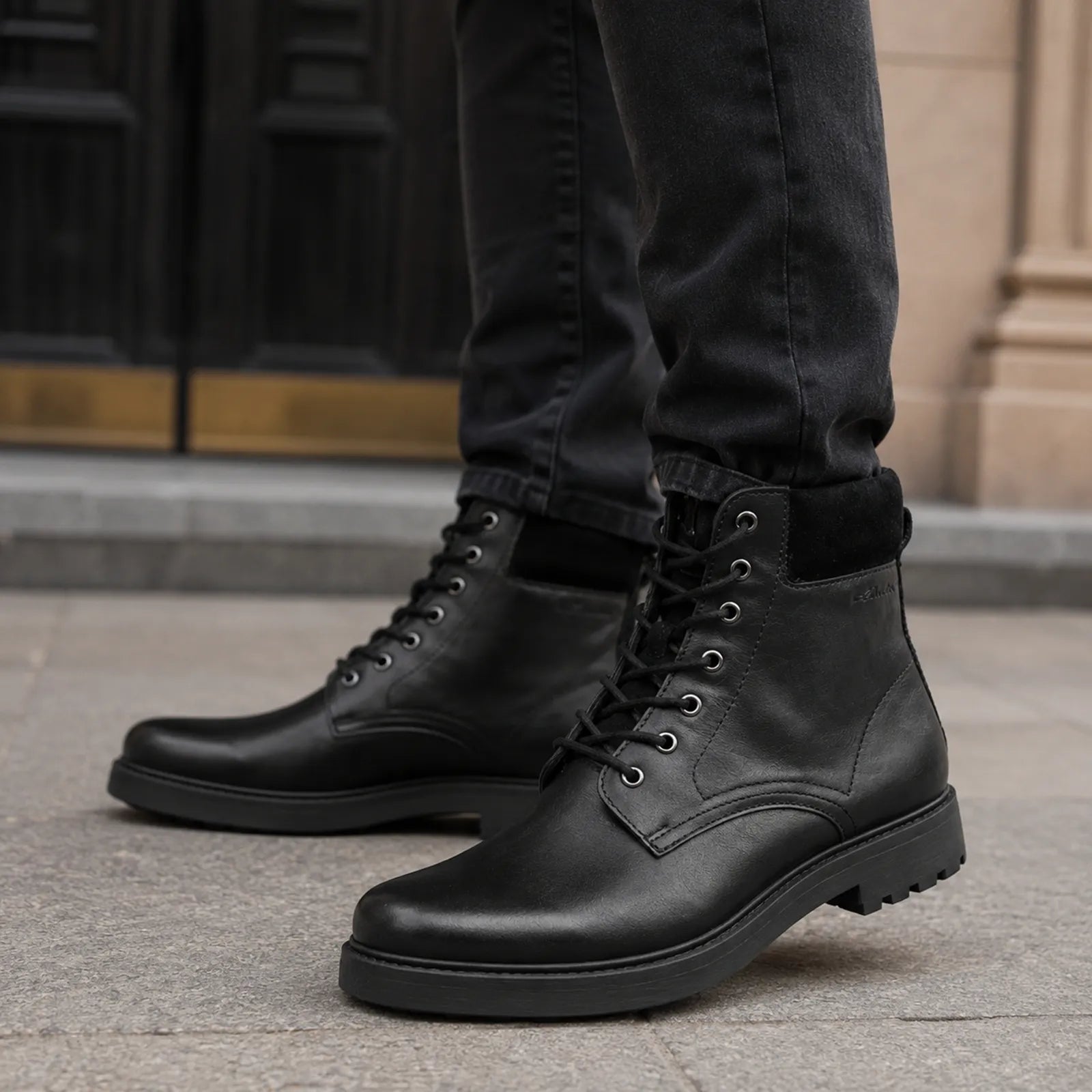Black leather lace-up high boots with rugged tread sole and stitched side panel.