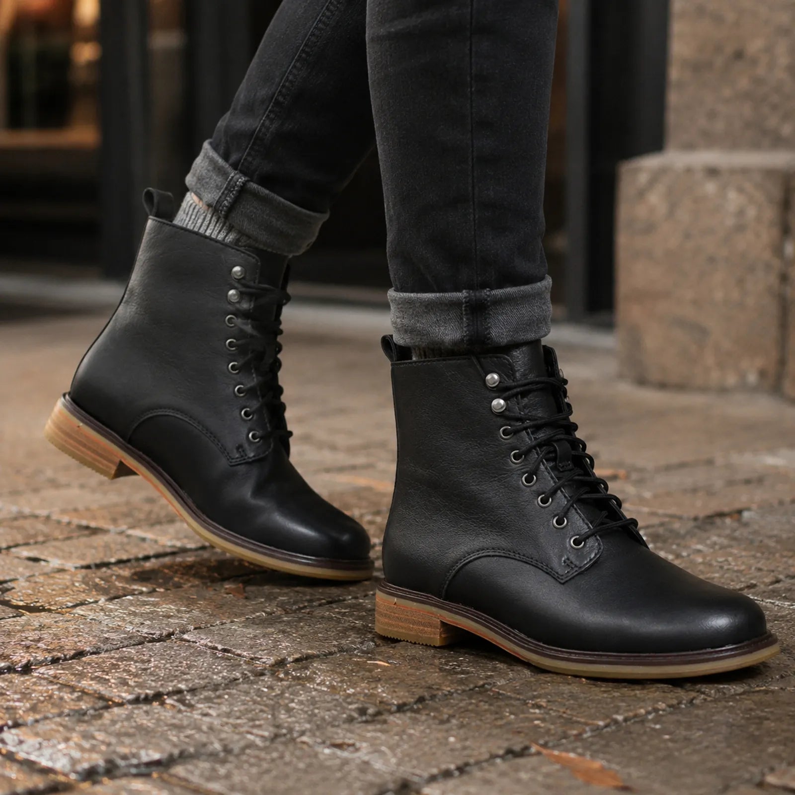 Black leather lace-up ankle boots with lace-up front and low heel sole.