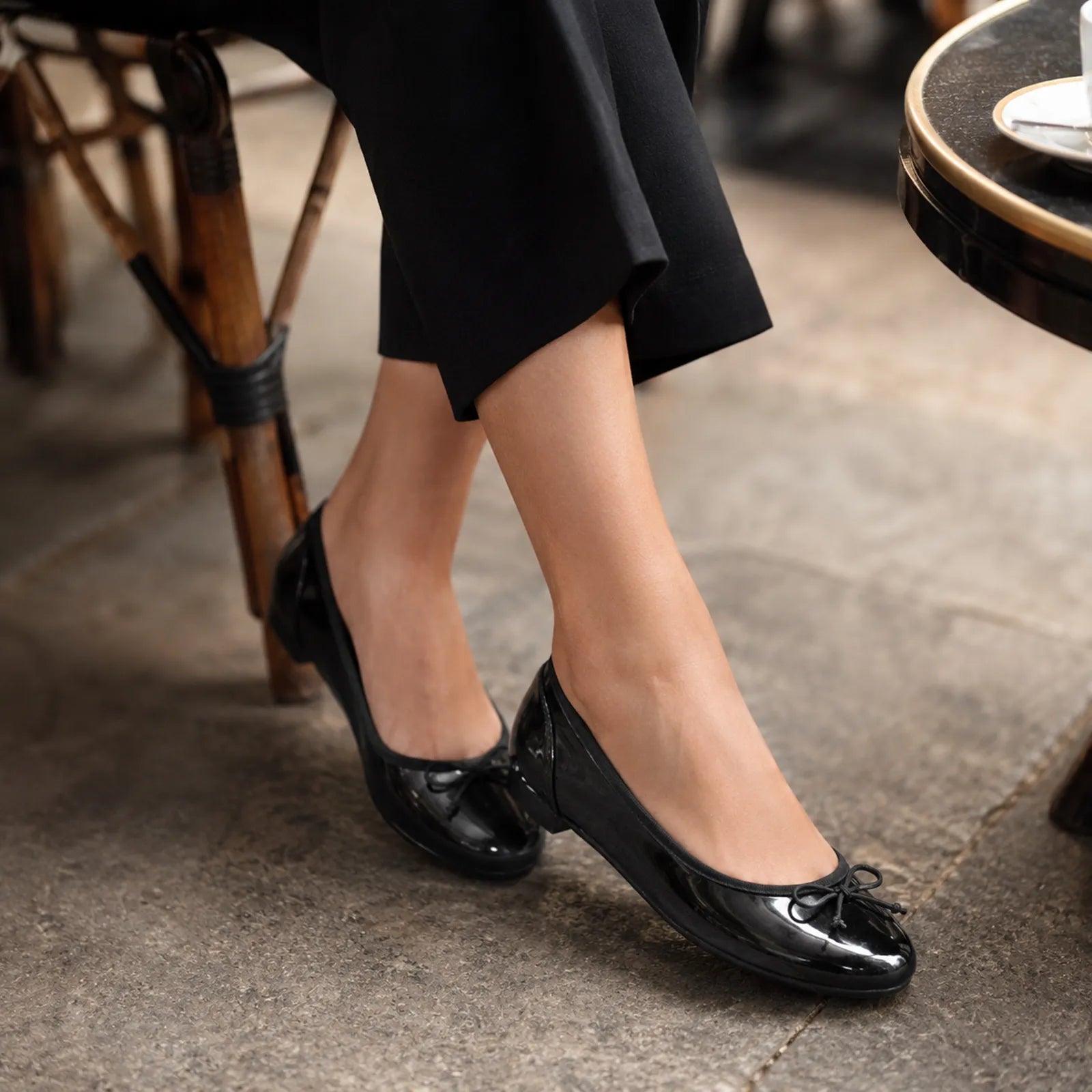 Black leather ballet flats with bow laces and low heel, close-up view