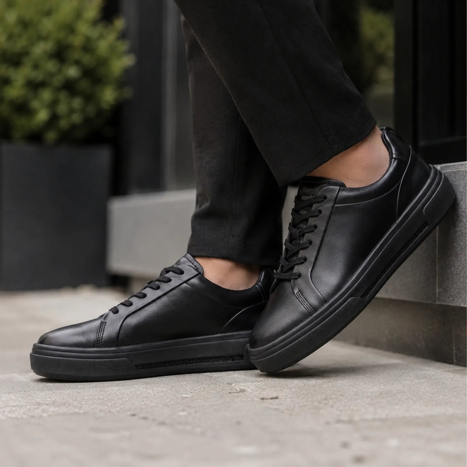 Black leather lace-up platform shoes stepping on pavement